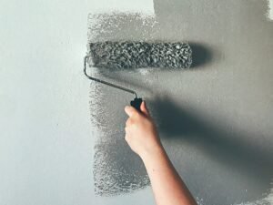 Woman painting wall with paint roller